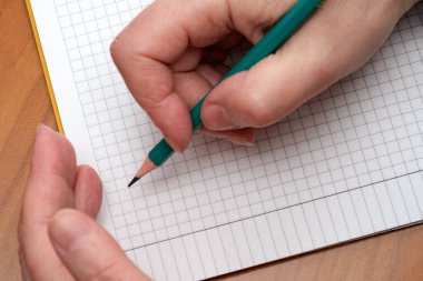 Dikkatlice yerleştirilmiş eller, kağıt üzerine şebeke tasarımları çizmeye hazır bir kalem tutuyorlar..