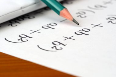 Akşam ışığı sırasında el yazısı matematik denklemlerinin üzerine odaklanmış kalem.