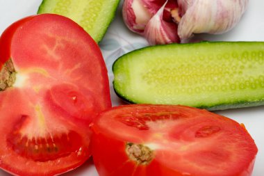 Dilimlenmiş domates ve salatalıkla birlikte sarımsak karanfilleri yemeğe hazır..