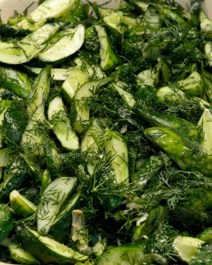 Çıtır salatalık dilimleri taze bitkilerle karışıp ferahlatıcı yaz lezzetleri sunar..