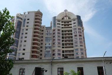 Uzun binalar mavi gökyüzüne karşı, Kyiv 'in canlı şehir yaşamını gözler önüne seriyor..