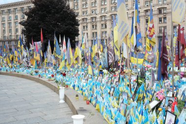Ukrayna kahramanlarının cesaretini onurlandıran bayrak ve fotoğraflarla kasvetli bir övgü..