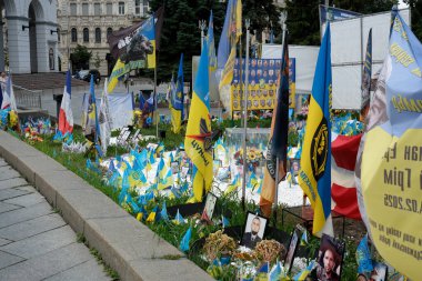 Renkli bayraklar ve fotoğraflar Ukraynalı kahramanların anısına resmi bir anıtta.