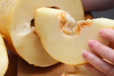 Bir el karpuz dilimini tutar, diğerleri yakınlarda dinlenirken, sulu iç kısımlarını gösterir..