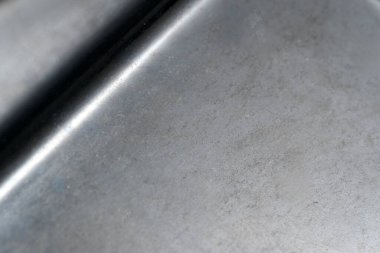 Koyu renk fırçalı metal yüzey gölgeli ve röfleli eşsiz bir doku sergiler.