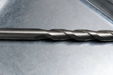 Keskin kenarı ve spiral dizaynını gösteren hassas matkap ucu yakın plan..