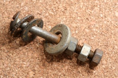 Eski bir cıvata ve fındık düzenleme kumaşlı bir yüzeye dayanır..