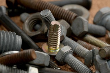 Ahşap bir çalışma yüzeyinde duran zengin bir metal donanım parçası çeşidi..