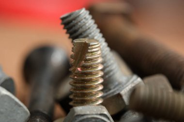 Paslı ve parlak metal bağlayıcılar çalışma alanını dolduruyor, dokularını renklendiriyor..