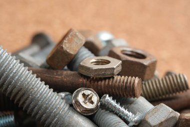 Çeşitli somunlar ve cıvatalar gelişigüzel bir iş yüzeyinde düzenlenir..
