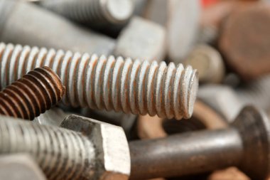 Metalik bağlayıcılar etrafa saçılmış, çeşitli şekil ve dokuları doğal ışıkta sergiliyor..