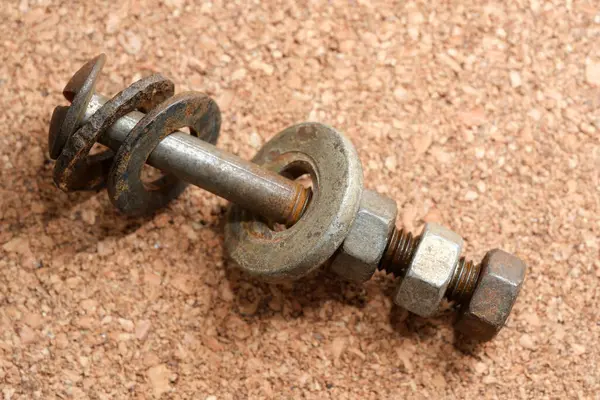 Eski bir cıvata ve fındık düzenleme kumaşlı bir yüzeye dayanır..