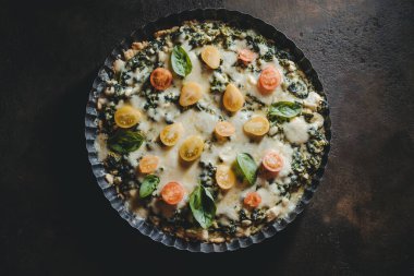 Ispanaklı ev yapımı turta, taze domates ve fesleğen yaprağı.