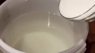 Ay ışığı için mayalanma zulasına şeker ekliyorum. Ev damıtma işleminin bir parçası