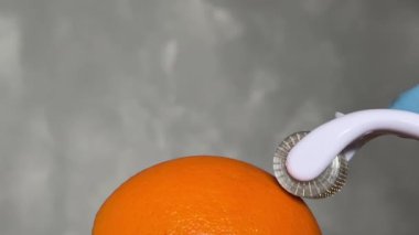 Kozmetik Derma Roller turuncu bir Cilt Konsepti üzerinde yuvarlanıyor. Dermaroller