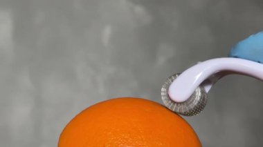 Kozmetik Derma Roller turuncu bir Cilt Konsepti üzerinde yuvarlanıyor. Dermaroller