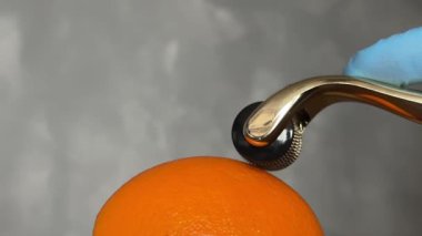 Kozmetik Derma Roller turuncu bir Cilt Konsepti üzerinde yuvarlanıyor. Dermaroller