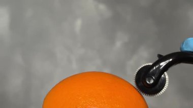 Kozmetik Derma Roller turuncu bir Cilt Konsepti üzerinde yuvarlanıyor. Dermaroller