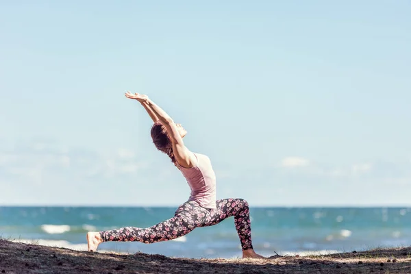 Junge Kaukasische Frau Praktiziert Yoga Der Küste Sommertag lizenzfreie Stockbilder