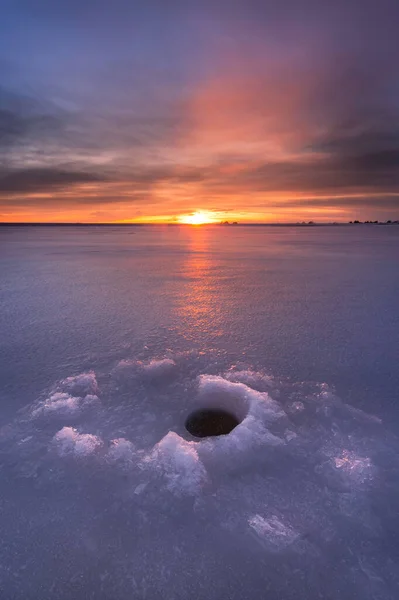 在冬天钓鱼是一项很受欢迎的运动 五彩缤纷的日出映照在冰封的湖面上 — 图库照片