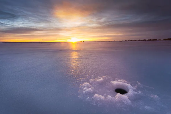 在冬天钓鱼是一项很受欢迎的运动 五彩缤纷的日出映照在冰封的湖面上 — 图库照片