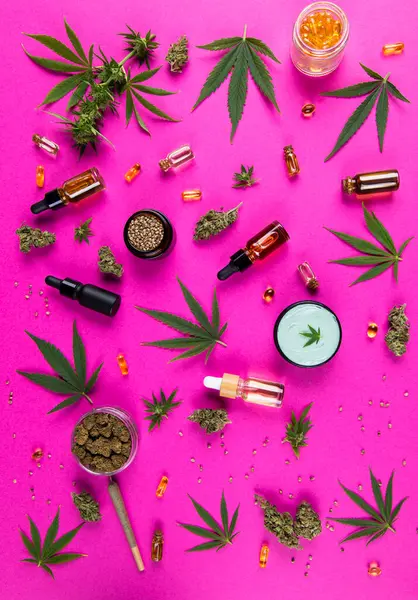 ピンクの紙の背景に大麻と麻油のトップビュー ロイヤリティフリーのストック画像