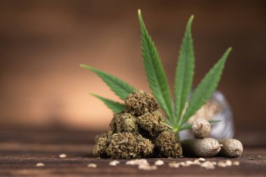 Ahşap arka planda marihuana tomurcukları olan kenevir yaprakları