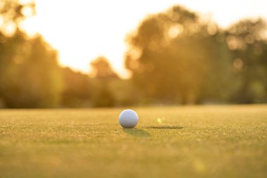 Golf sahasında gün batımında arka planda golf.