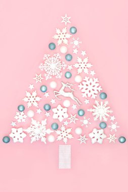 Gerçeküstü Noel ağacı şekilli süslemeler kar tanesi, ren geyiği, yıldız ve top süslemeleri içeren soyut kuzey kutbu konsepti pembe arka planda. Noel tatili için eğlenceli büyülü tasarım.. 