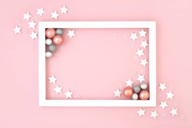 Noel ve Yeni Yıl şenliği arka planında kar taneli pastel pembeler ve beyaz çerçeveli yuvarlak ağaç süslemeleri var. Tatil sezonu için en düşük sınır tasarımı.