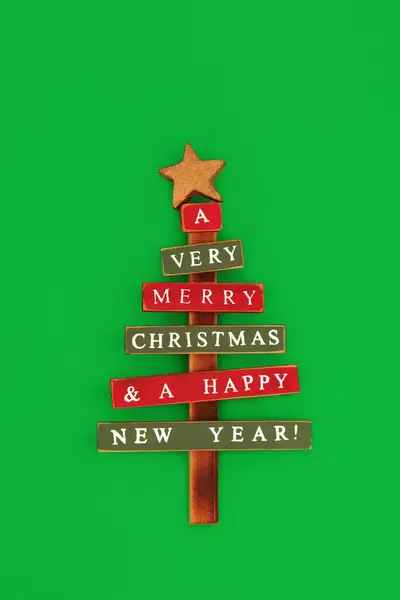 緑の背景に環境に優しい木製のクリスマスツリーの装飾 Xmasと緑の背景に新年の休暇シーズンのための素朴な古いファッションレトロミニマルデザイン — ストック写真