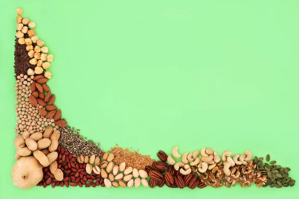 脂質が高い健康食品コレクション 成分はナッツ マメ科植物や穀物と健康的な心とコレステロールレベルのための不飽和脂肪が含まれています 緑の背景に トップ表示 ロイヤリティフリーのストック写真