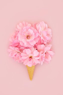 Gül çiçeği buketli dondurma külahı pembe arka planda. Yaz asgari gerçeküstü çiçek yaratıcı sanat konsepti. Sevgililer Günü, Anneler Günü, yıldönümü ya da doğum günü tasarımı için.. 