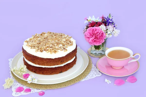 紫色の背景に茶と夏の花のカップとニンジンとクルミのケーキ アフタヌーンティーや誕生日パーティーのための自家製おいしい料理のコンセプト — ストック写真