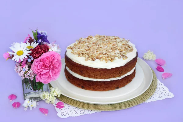 紫色の背景に夏の花とニンジンとくるみのケーキ アフタヌーンティーや誕生日パーティーのための自家製おいしい料理のコンセプト — ストック写真