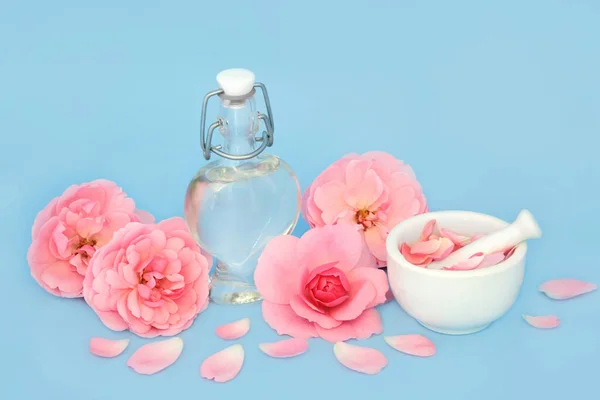 玫瑰花芬芳在心形瓶与花和松散的花瓣蓝色 准备香花制品 情人节礼物 周年纪念日或母亲节 — 图库照片
