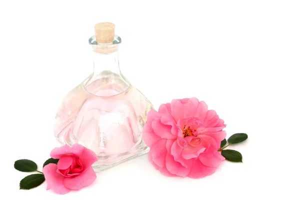 Rosewater with pink rose flowers on white background. Natural alternative skincare to hydrate skin, treats skin redness, irritation, scars, burns, restores ph balance.