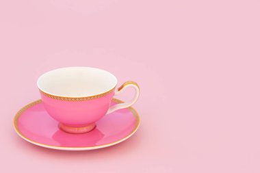 Pembe ve altın kemikli porselen çay fincanı. Pastel pembe arka planda fotokopi alanı olan lüks bir içki seti. En düşük zen bileşimi.