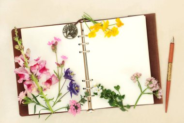 Çiçekler, kır çiçekleri, defter ve mürekkep kalemle. Aromaterapide ve doğal bitkisel ilaçlarda kenevir kağıdı arka planında alternatif ilaçlar için kullanılır..