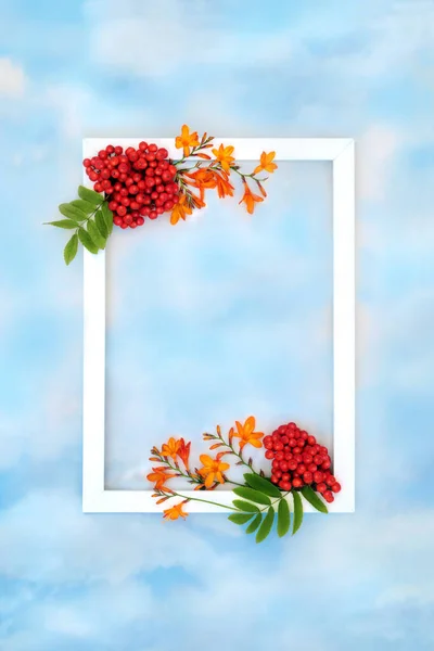 Autumn harvest festival fruit and flower background border with white frame on blue sky and cloud. Festive floral fall Thanksgiving nature concept for label, card, invitation, menu.