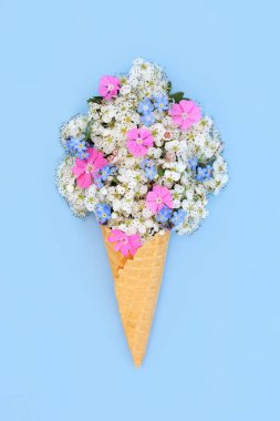 Gerçeküstü dikenli çiçek, beni unutma ve gül çadırı çiçekli dondurma külahı konsepti. Logo, hediye etiketi, doğum günü, anneler günü, mavi üzerine tatil tatili için yenilebilir yemek sanatı bahar kompozisyonu.