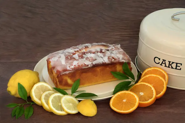 소박한 배경에 신선한 과일과 케이크 주석과 레몬과 오렌지 드리즐 아이스 스톡 사진