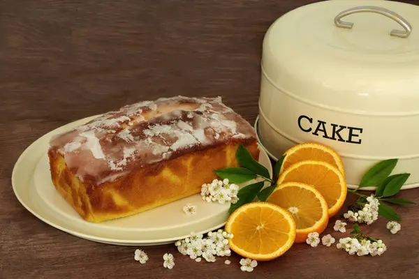 橙色细雨蛋糕 新鲜水果 春花和蛋糕罐在乡村木料背景 庆祝活动自制甜点 图库图片