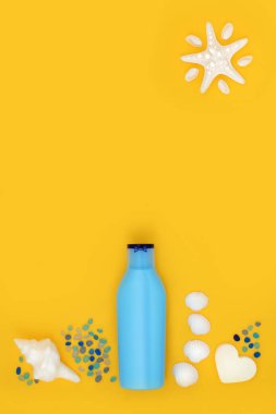 Yaz cilt bakımı için güneş kremi mavi konteynır şişesi ve sarı deniz kenarında tatil sembolleri. Kanser karşıtı tatil seyahati sağlık hizmeti konsepti.