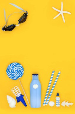Yaz tatili sahil aksesuarları ve güneş kremi ve yüzme gözlükleriyle süslemeler. Seyahat tatili konsepti sarı arka planda..
