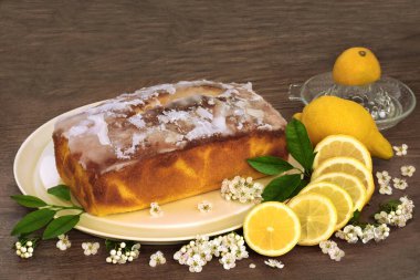 Taze meyve, yaprak, bahar dikenli çiçek ve ahşap arka planda sıkmalı limonlu kek. Kutlama etkinlikleri için ev yapımı tatlı.