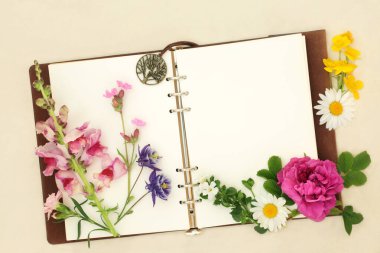 Çiçekler bitkiler ve defter ile kır çiçekleri. Aromaterapi ve doğal bitkisel ilaçlarda kullanılır. Kenevir kağıdı arka planında alternatif çözümler için çiçek özleri.