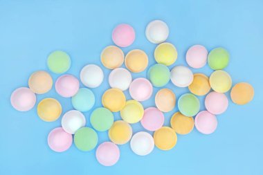 Flying saucer sherbet sweet treat food on blue background. Abstract multicolored design of old fashioned fizzy candy confectionery. clipart