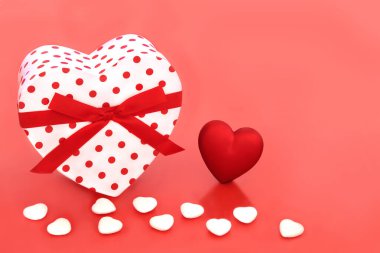 Romantik sevgililer günü kalp şeklinde hediye kutusu ve kırmızı arka planda dekoratif kalpler. Sevgililer günü kartı, yıldönümü ya da doğum günü için aşk konsepti.