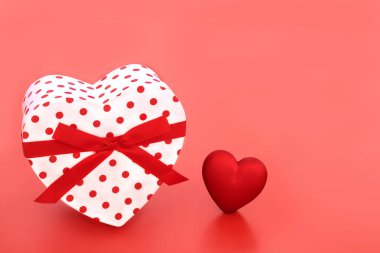 Kırmızı arka planda kalp şeklinde Sevgililer Günü hediye kutusu. Sevgililer günü kartı, yıldönümü ya da doğum günü için aşk tutku konsepti.